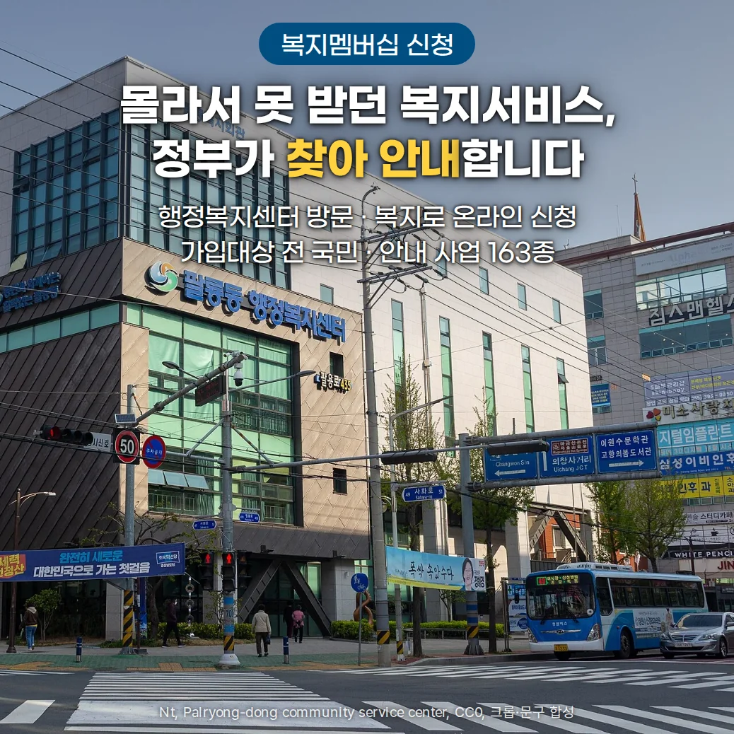 맑은 하늘 아래 '팔룡동 행정복지센터' 간판을 단 청사와 앞 횡단보도, 정류장에 선 버스. 위쪽 가운데에 '복지멤버십 신청' 배지와 '몰라서 못 받던 복지서비스, 정부가 찾아 안내합니다'라는 제목, '행정복지센터 방문 · 복지로 온라인 신청, 가입대상 전 국민 · 안내 사업 163종' 문구가 있습니다