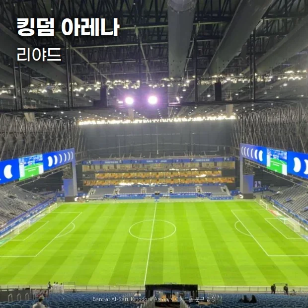 관중이 없는 리야드 킹덤 아레나 내부. 철골 지붕 구조 아래 양쪽 대형 스크린과 초록 그라운드가 보입니다
