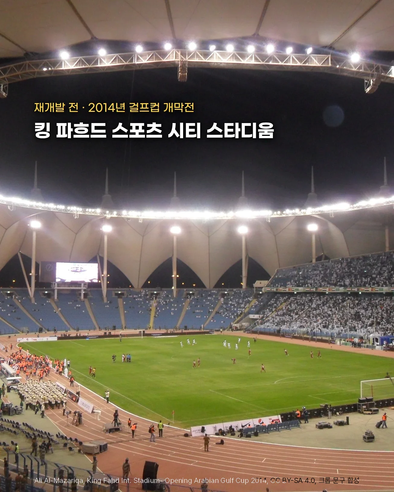 2014년 걸프컵 개막전이 치러진 밤의 리야드 킹 파흐드 국제 스타디움. 원형 지붕 안쪽을 따라 조명이 둥글게 켜져 있고, 관중이 들어찬 관중석 아래로 육상 트랙과 초록 그라운드가 보입니다. 재개발 전 모습입니다