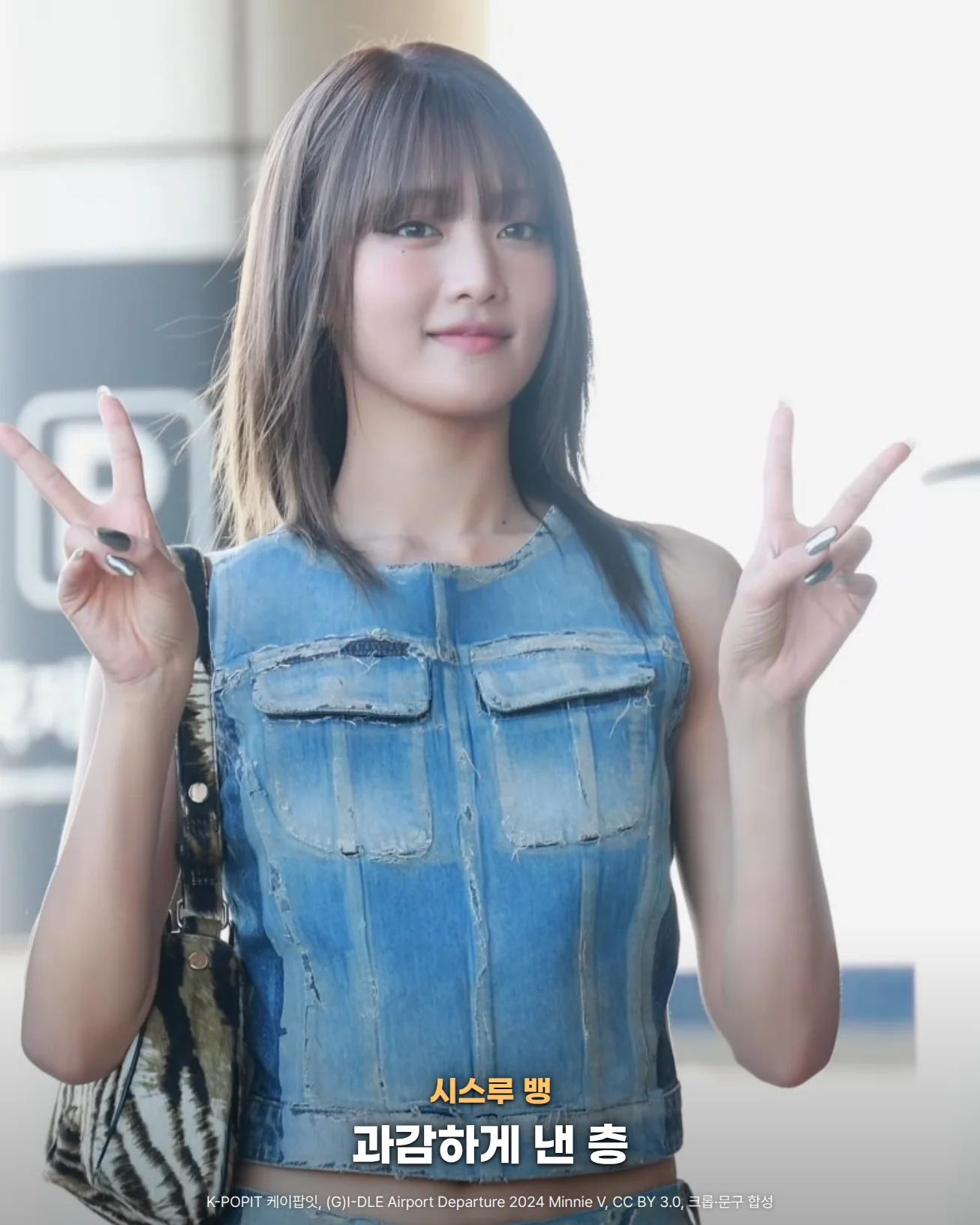 시스루 앞머리에 어깨선 위에서 끝이 가볍게 뻗치는 갈색 중단발을 한 (G)I-DLE 민니가 데님 상의를 입고 두 손으로 브이를 하는 사진입니다. 아래쪽에 시스루 뱅, 과감하게 낸 층이라는 문구가 있습니다