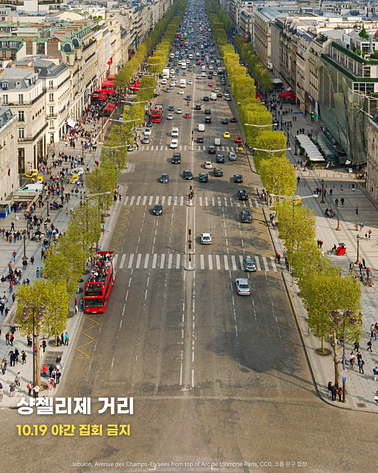 개선문 위에서 내려다본 샹젤리제 거리입니다. 가운데로 곧게 뻗은 차로에 차량이 오가고, 양쪽에 가로수와 석조 건물이 늘어서 있으며, 인도에는 사람들이 걷고 있습니다. 아래쪽 차로 위에 '샹젤리제 거리'와 '10.19 야간 집회 금지'라는 글자가 놓여 있습니다.