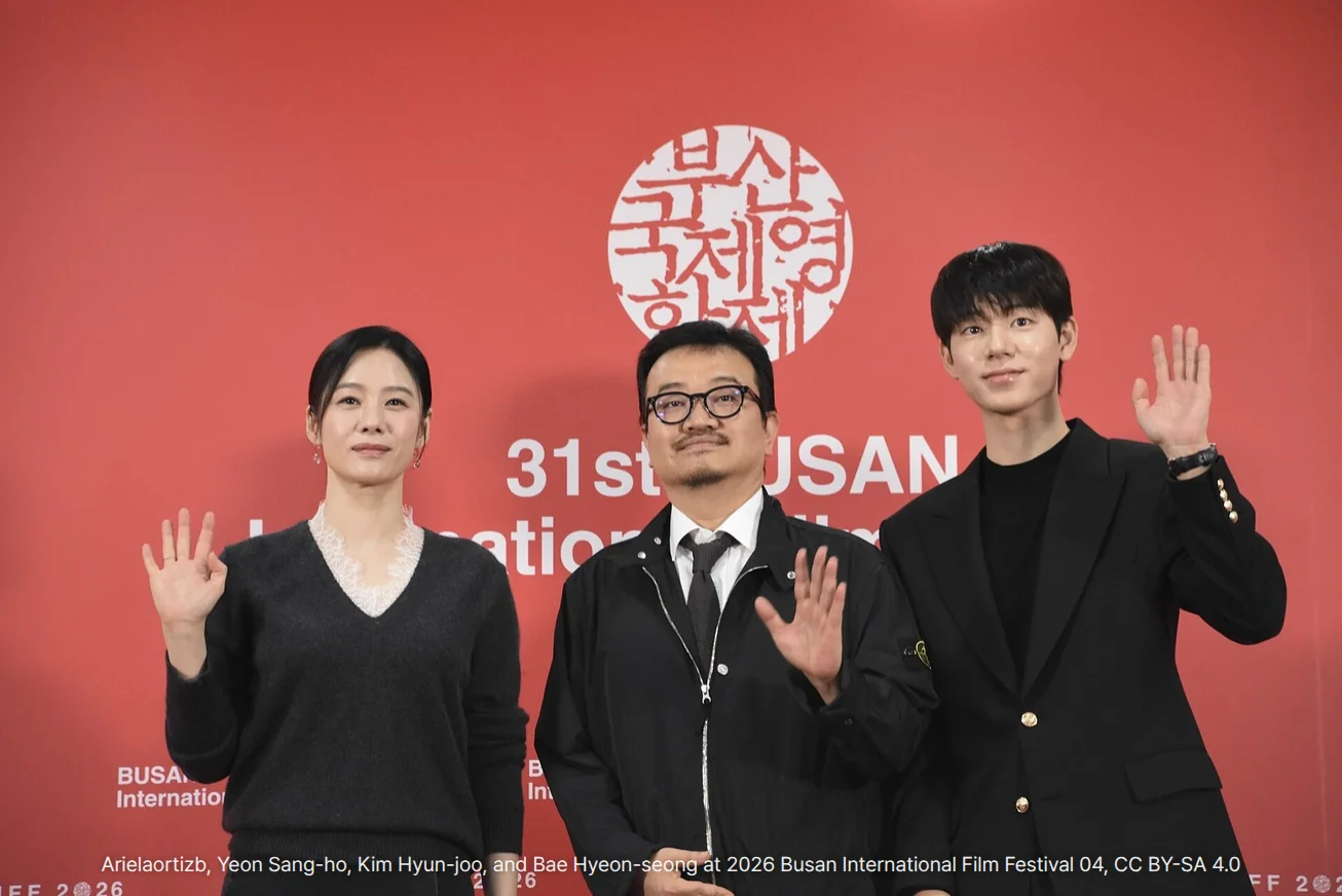 제31회 부산국제영화제 실낙원 기자회견 사진. 부산국제영화제 로고가 있는 붉은 배경 앞에서 왼쪽부터 김현주, 연상호 감독, 배현성이 나란히 서서 손을 흔들고 있습니다