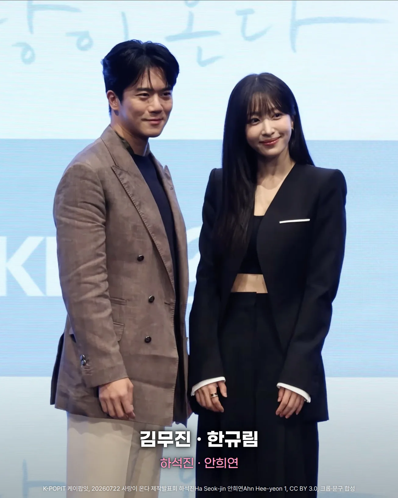사랑이 온다 제작발표회 무대에서 '사랑이 온다' 글자가 있는 하늘색 배경 앞에 갈색 체크 재킷을 입은 하석진과 검은 정장을 입은 안희연이 나란히 선 사진. 아래쪽에 '김무진 · 한규림'과 '하석진 · 안희연' 문구가 있습니다.