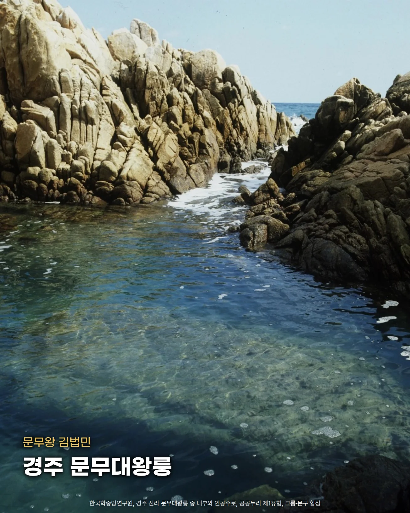 경주 신라 문무대왕릉 안쪽. 양쪽의 거친 바위 사이로 바닷물이 흘러들어 맑은 물웅덩이를 이루고, 물 아래로 넓은 바위가 비칩니다. 아래쪽 물 위에 '문무왕 김법민'과 '경주 문무대왕릉' 글자를 넣은 사진입니다.