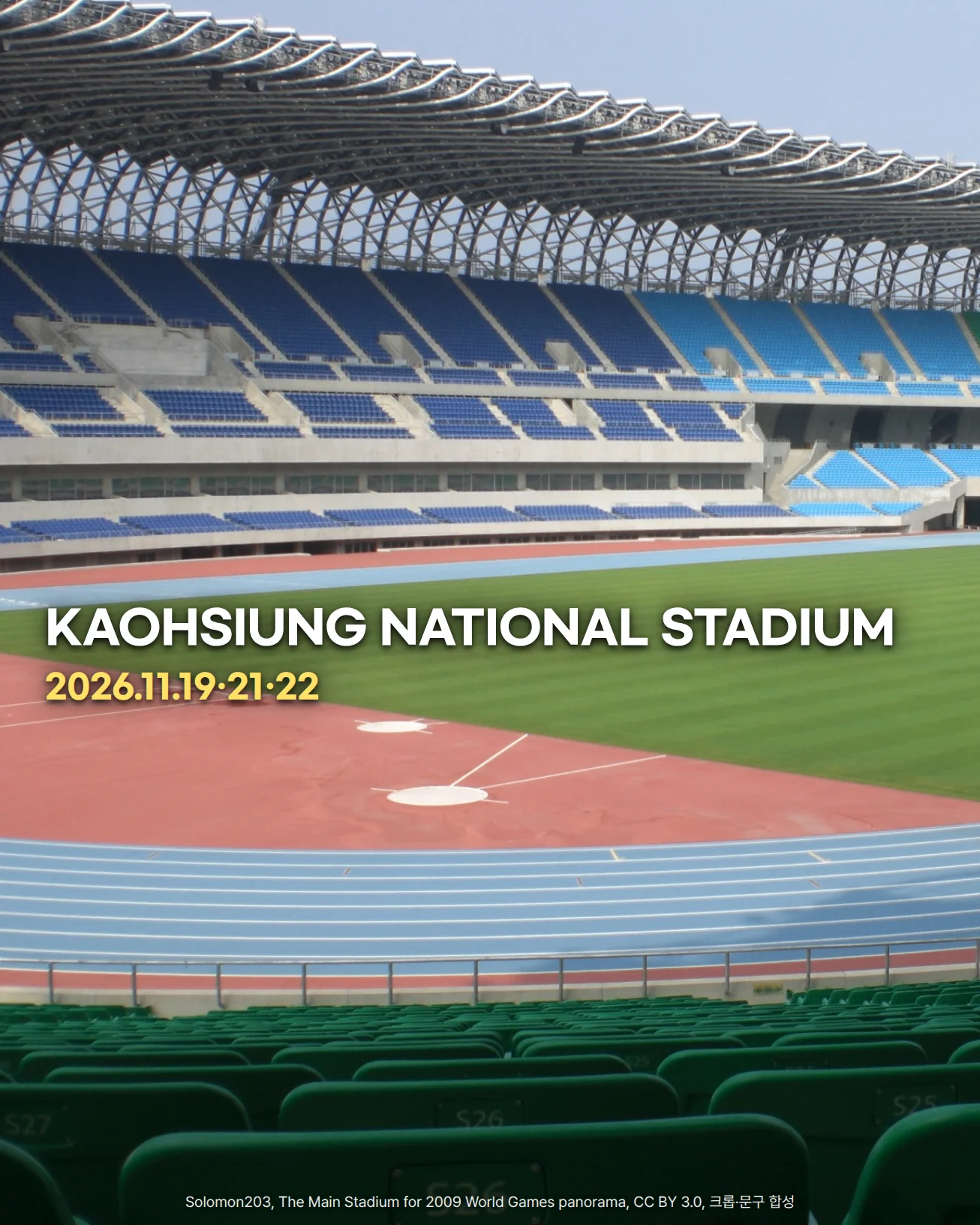 가오슝 Kaohsiung National Stadium을 아래쪽 초록 관중석에서 바라본 사진입니다. 물결 모양 철골 지붕 아래 파란색 관중석이 이어지고, 그 앞에 잔디 구장과 파란 트랙이 있습니다. 잔디 위에 'KAOHSIUNG NATIONAL STADIUM'과 '2026.11.19·21·22' 문구가 있습니다.
