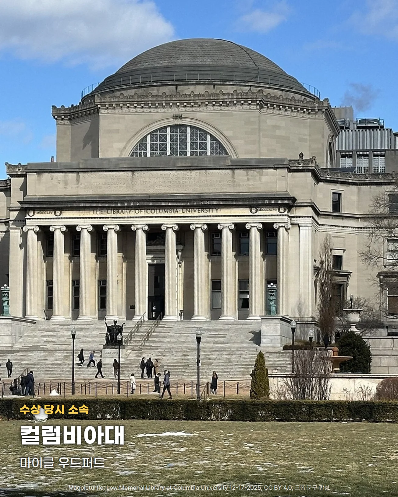 맑은 하늘 아래 큰 돔과 열 개의 기둥이 늘어선 현관, 넓은 돌계단이 있는 컬럼비아대 로우 기념 도서관 정면 사진. 앞쪽 잔디밭 위에 '수상 당시 소속', '컬럼비아대', '마이클 우드퍼드' 글자를 넣었습니다.