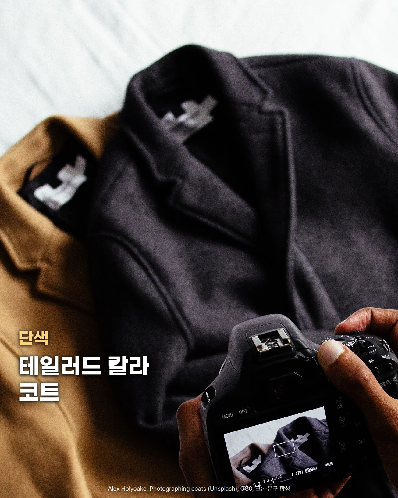 흰 침구 위에 테일러드 칼라가 달린 짙은 회색 울 코트와 카멜색 코트가 겹쳐 놓여 있고, 오른쪽 아래에서 두 손이 사진기로 코트를 찍고 있습니다. 왼쪽 아래에 단색, 테일러드 칼라 코트라는 문구가 있습니다