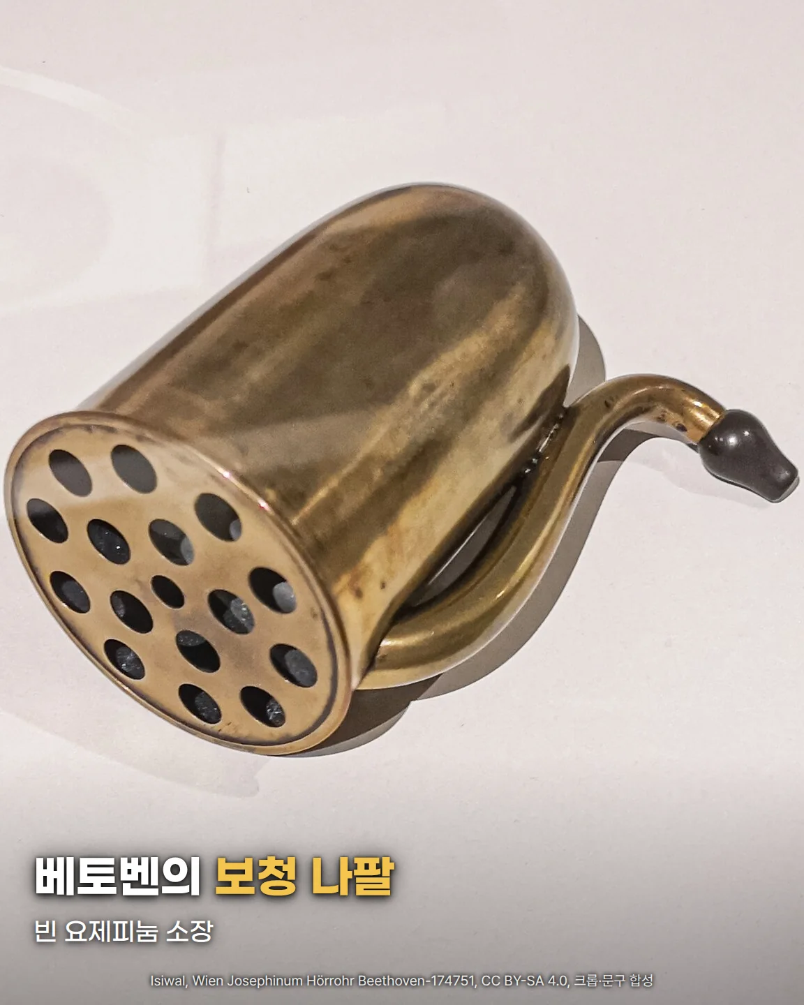 빈 요제피눔에 보관된 베토벤의 놋쇠 보청 나팔. 구멍이 여럿 뚫린 둥근 입구와 귀에 대는 굽은 관이 흰 바탕 위에 놓여 있고, 아래쪽에 '베토벤의 보청 나팔' '빈 요제피눔 소장' 글자가 있음