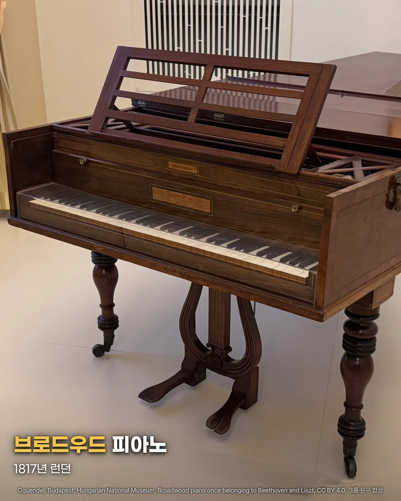 부다페스트 헝가리 국립박물관에 전시된, 베토벤과 리스트가 소유했던 브로드우드 그랜드 피아노. 짙은 갈색 나무 몸체에 보면대가 펼쳐져 있고 건반과 리라 모양 페달 받침, 둥근 나무 다리가 보이며, 아래쪽에 '브로드우드 피아노' '1817년 런던' 글자가 있음