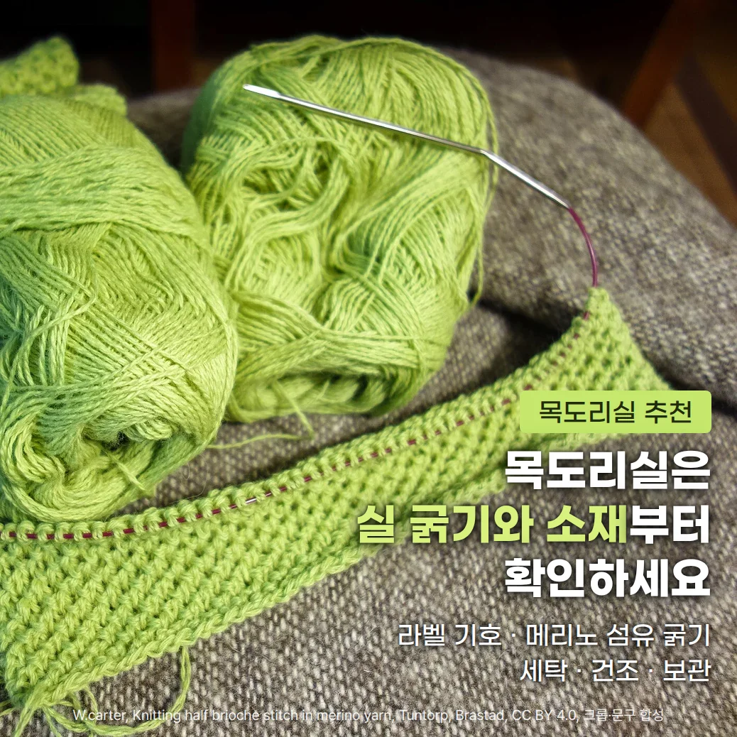 회색 모직 담요 위에 놓인 연두색 메리노 실 타래 두 개와 줄바늘에 걸려 있는 같은 색의 편물, 오른쪽 아래에 '목도리실 추천' 배지와 '목도리실은 실 굵기와 소재부터 확인하세요' 제목, '라벨 기호 · 메리노 섬유 굵기, 세탁 · 건조 · 보관' 부제가 있습니다