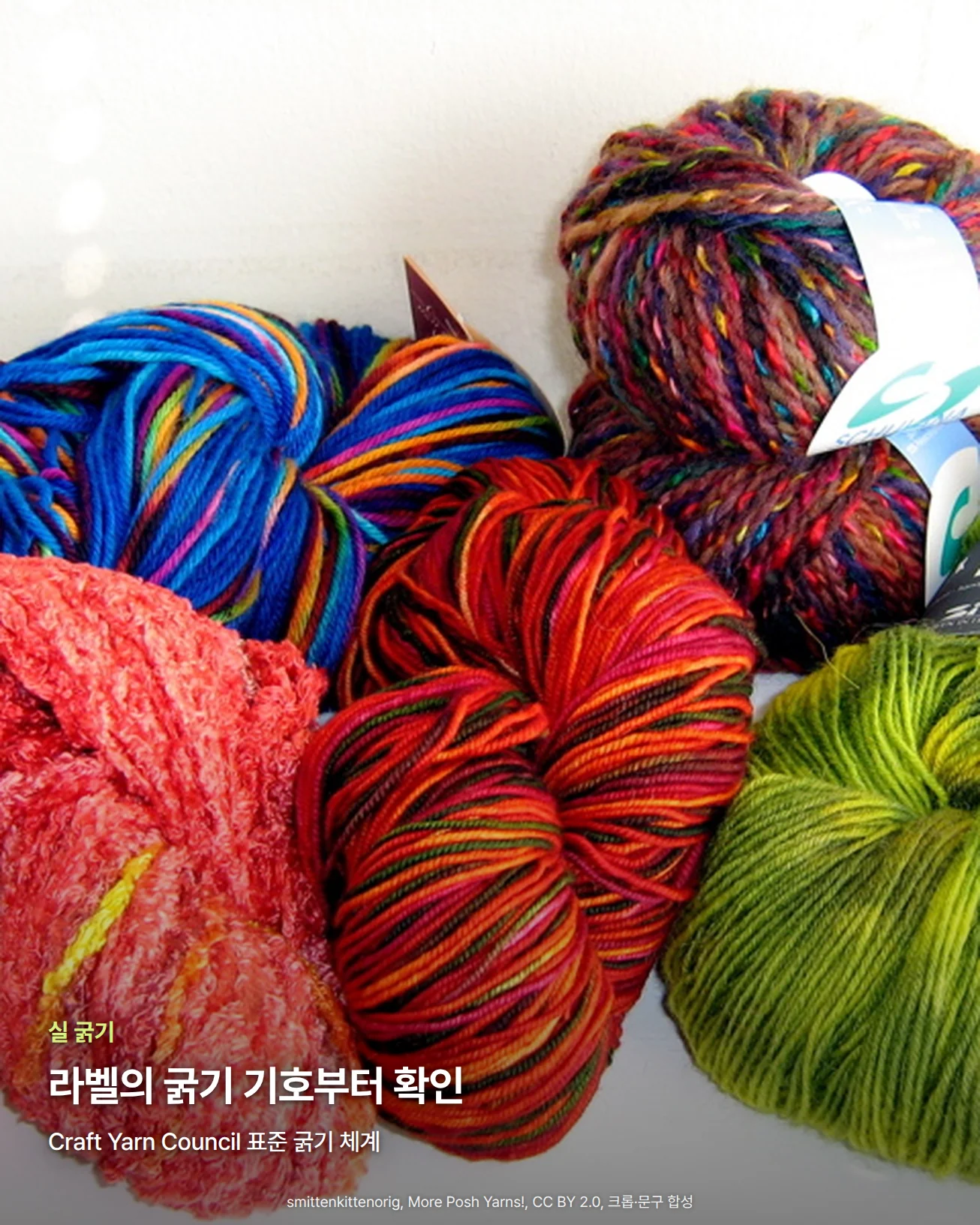 흰 벽 앞에 파랑, 주황·빨강, 여러 색이 섞인 실과 연두·초록 실 타래가 모여 있는 사진입니다. 실마다 굵기와 꼬임, 보송한 정도가 서로 다릅니다. 아래쪽에 '실 굵기' 문구와 '라벨의 굵기 기호부터 확인' 제목, 'Craft Yarn Council 표준 굵기 체계' 문구가 있습니다.
