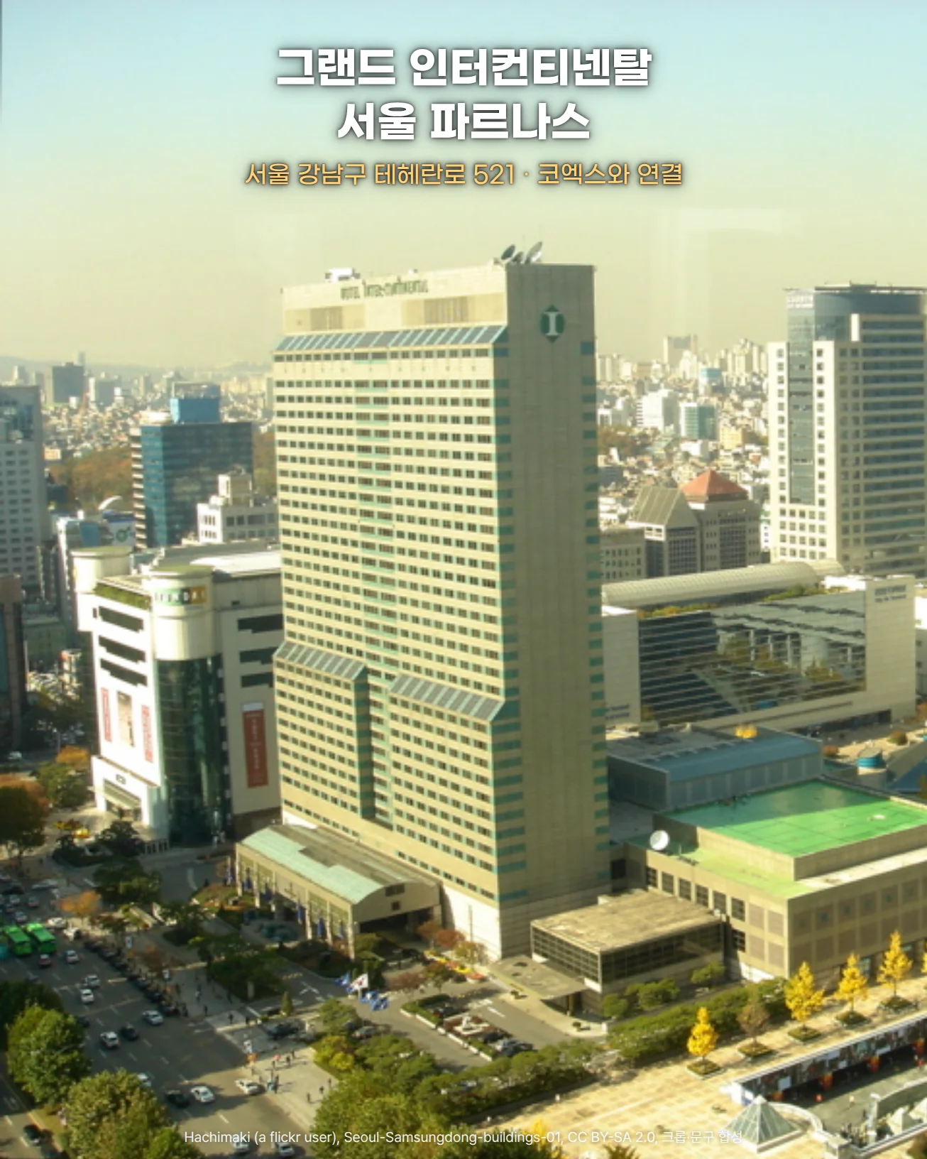 삼성동 고층에서 내려다본 도심 사진. 꼭대기에 HOTEL Inter-Continental 간판이 있는 호텔 타워가 가운데 높이 솟아 있고, 왼쪽 아래로 차들이 오가는 테헤란로, 오른쪽 아래로 초록 지붕의 저층 건물과 은행나무가 늘어선 광장이 보이며, 위쪽 하늘에 '그랜드 인터컨티넨탈 서울 파르나스'와 '서울 강남구 테헤란로 521 · 코엑스와 연결' 문구가 놓인 사진