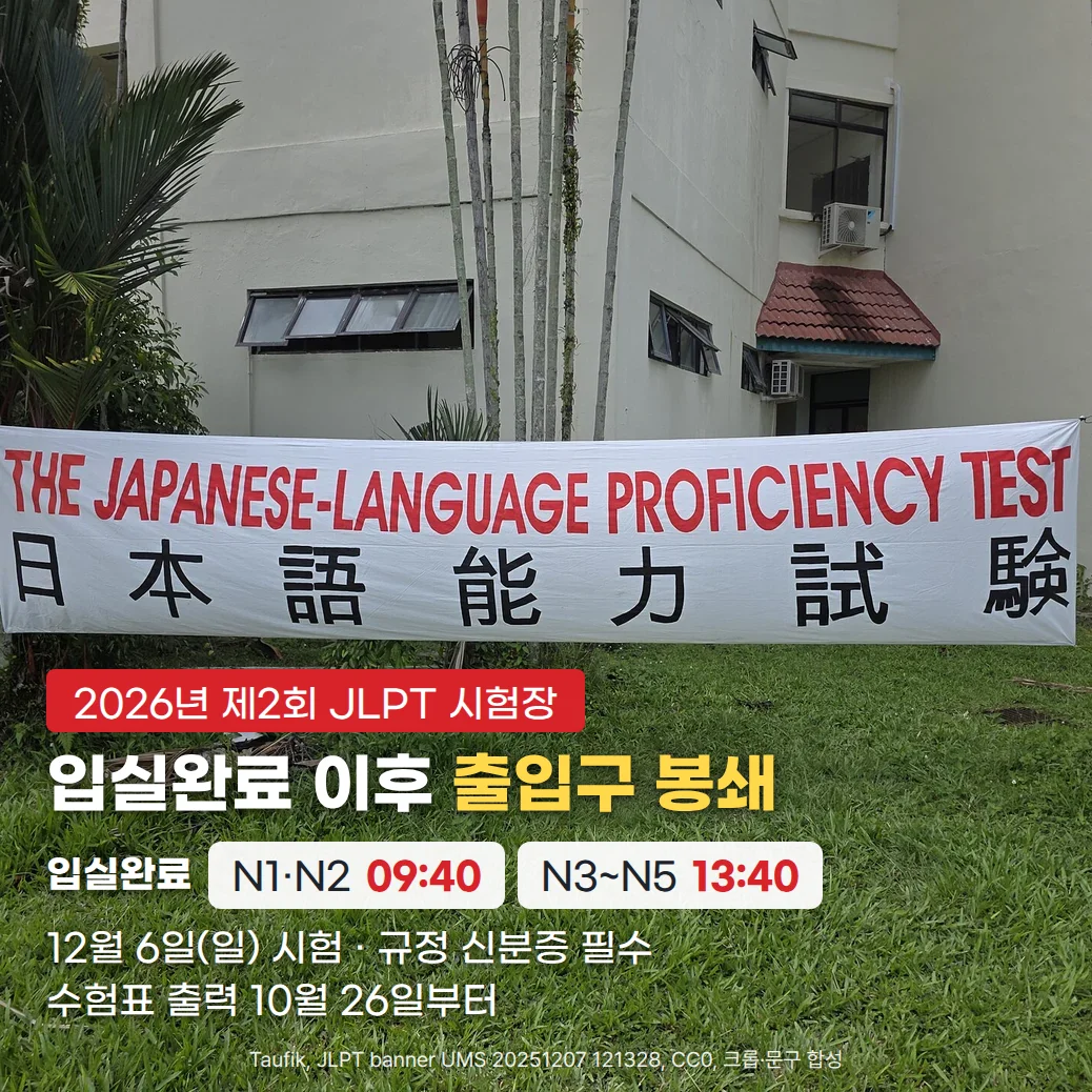 건물 앞 잔디밭에 'THE JAPANESE-LANGUAGE PROFICIENCY TEST 日本語能力試験' 현수막이 걸린 시험장 사진 위에 '2026년 제2회 JLPT 시험장' 배지, '입실완료 이후 출입구 봉쇄' 제목, 입실완료 N1·N2 09:40과 N3~N5 13:40, '12월 6일(일) 시험 · 규정 신분증 필수', '수험표 출력 10월 26일부터' 문구가 있는 커버